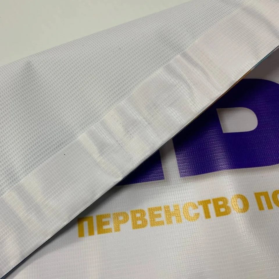 Проварка края баннера крупным планом — термосварной шов по периметру полотна